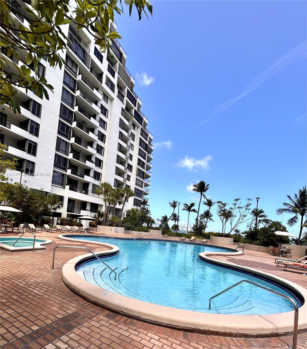 520 Brickell Key Drive, Unit A1421 Miami, FL 33131 - Photo 33 of 34 a view of swimming pool with outdoor seating and buildings in the background