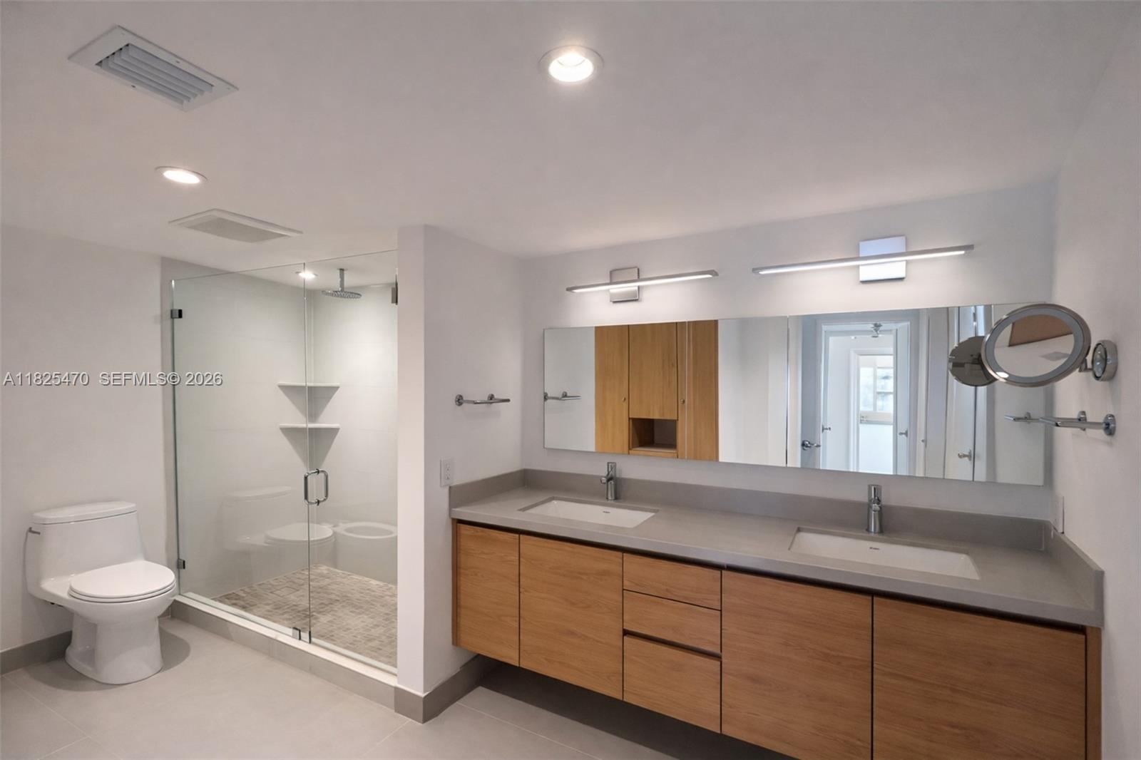 520 Brickell Key Drive, Unit A1421 Miami, FL 33131 - Photo 8 of 16 a bathroom with a granite countertop sink a toilet a mirror and shower