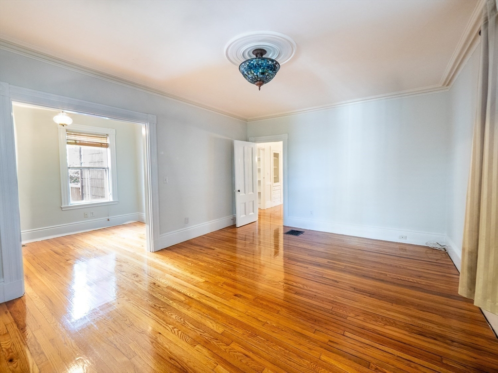 12 Adella Place Boston, MA 02134 - Photo 3 of 36 a view of an empty room with wooden floor and a window