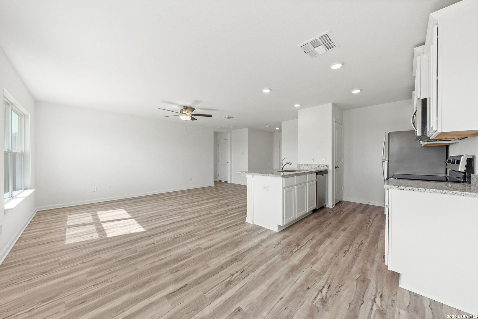 16189 Farmer Lytle, TX 78052 - Photo 6 of 28 a view of kitchen with kitchen island wooden floors appliances and cabinets