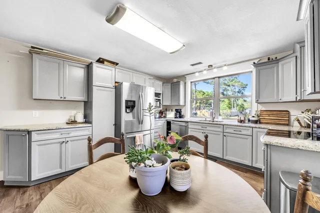 a kitchen with granite countertop kitchen island cabinets and chairs in it