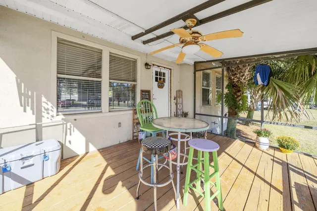 a view of an empty room with wooden floor and furniture