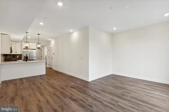a view of a kitchen with granite countertop a sink cabinets and stainless steel appliances