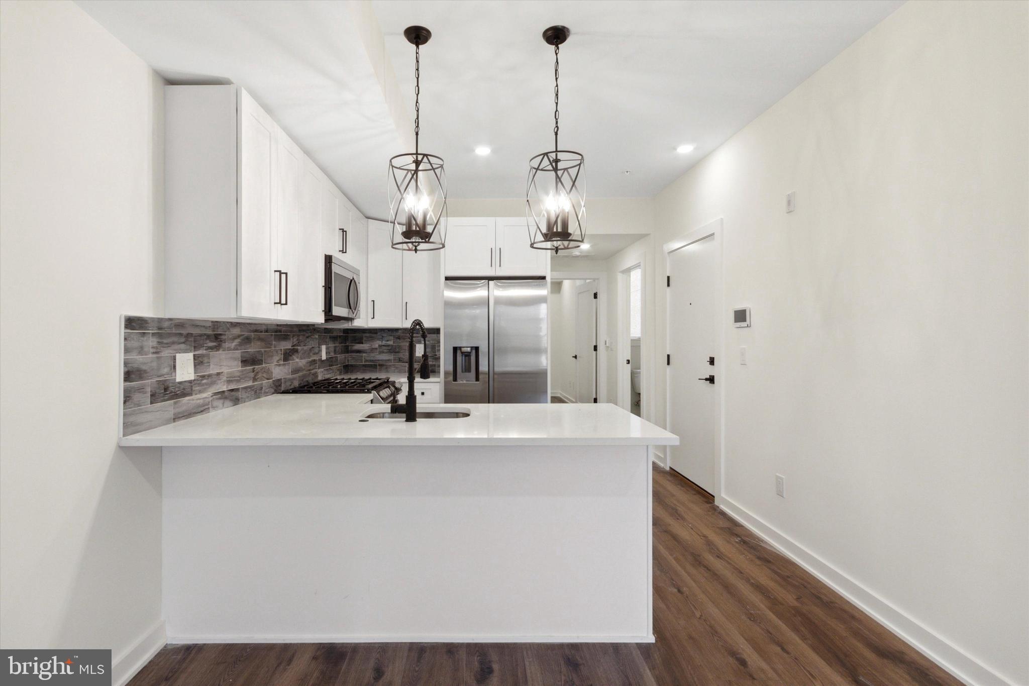 1826 Frankford Avenue, Unit 3 Philadelphia, PA 19125 - Photo 14 of 18 a view of a kitchen with granite countertop a sink cabinets and stainless steel appliances
