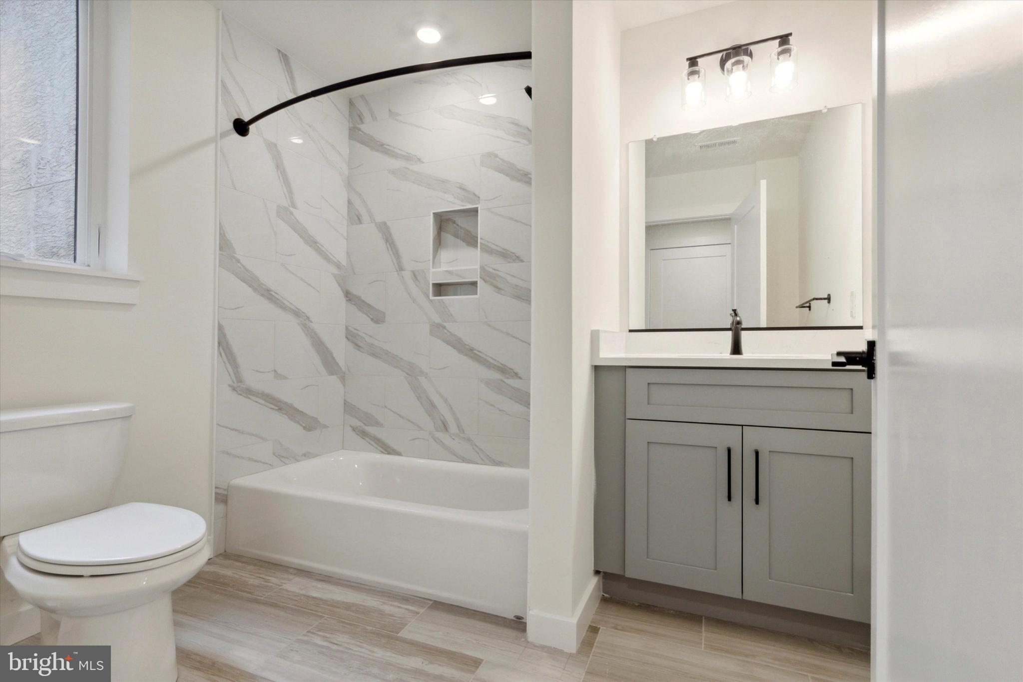 1826 Frankford Avenue, Unit 3 Philadelphia, PA 19125 - Photo 17 of 18 a bathroom with a sink a toilet and shower