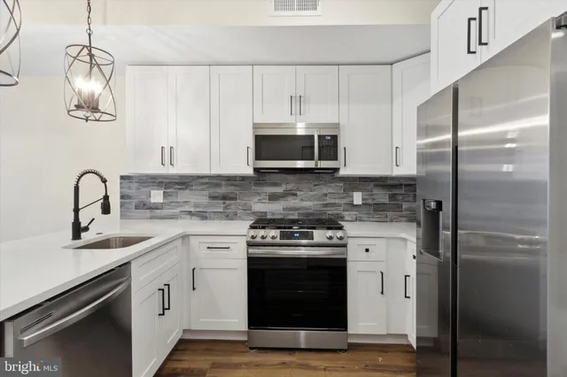 a kitchen with a sink cabinets and stainless steel appliances
