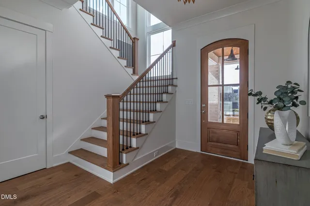 a kitchen with stainless steel appliances granite countertop a sink a stove a refrigerator and island with wooden floor