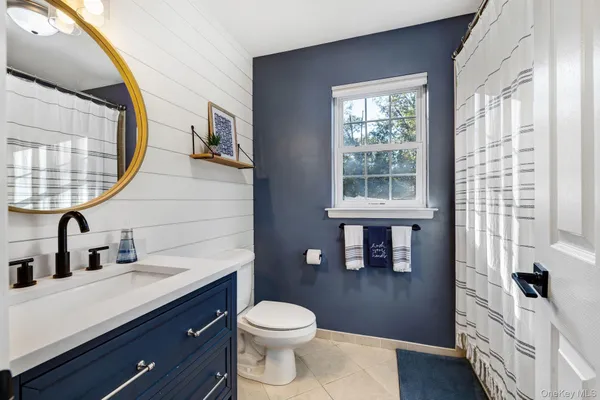 a bathroom with a sink a toilet and a mirror