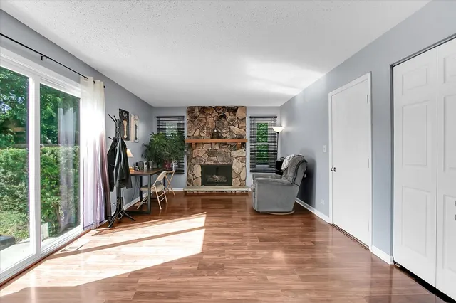 a living room with furniture a large window and a fireplace