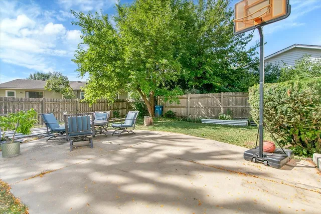 a backyard of a house with table and chairs