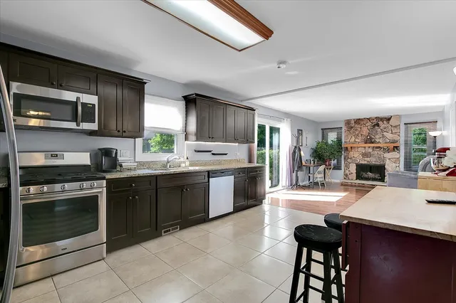 a kitchen with stainless steel appliances granite countertop a stove refrigerator and a sink