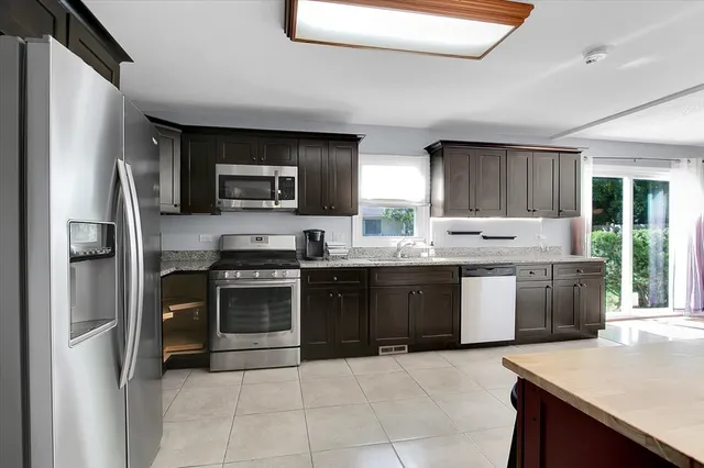 a kitchen with a sink refrigerator and cabinets
