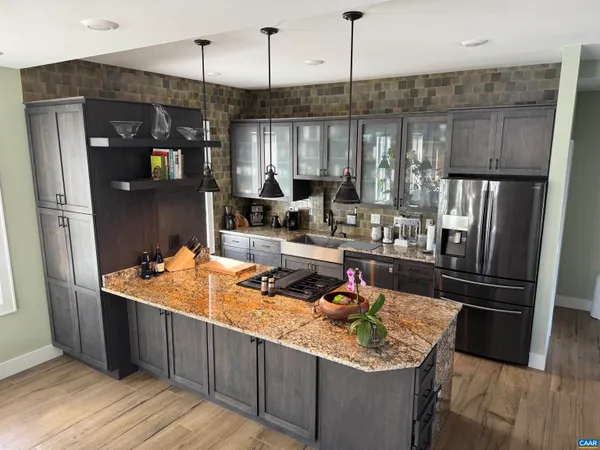 a kitchen with stainless steel appliances granite countertop a sink refrigerator and cabinets