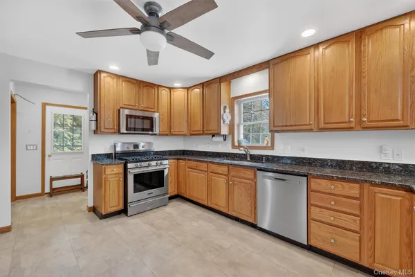 a kitchen with granite countertop a stove sink and microwave