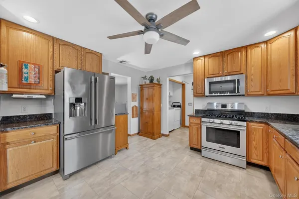 a kitchen with stainless steel appliances granite countertop a refrigerator stove and oven