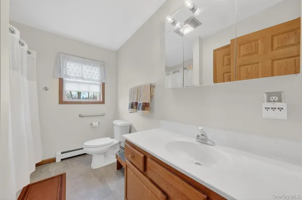 a bathroom with a sink toilet and a mirror