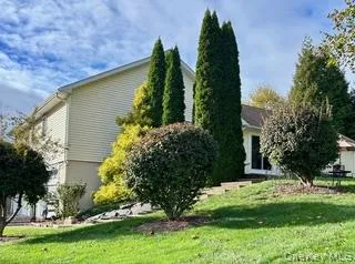 a view of a house with potted plants and large trees