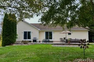 a view of house with yard and parking