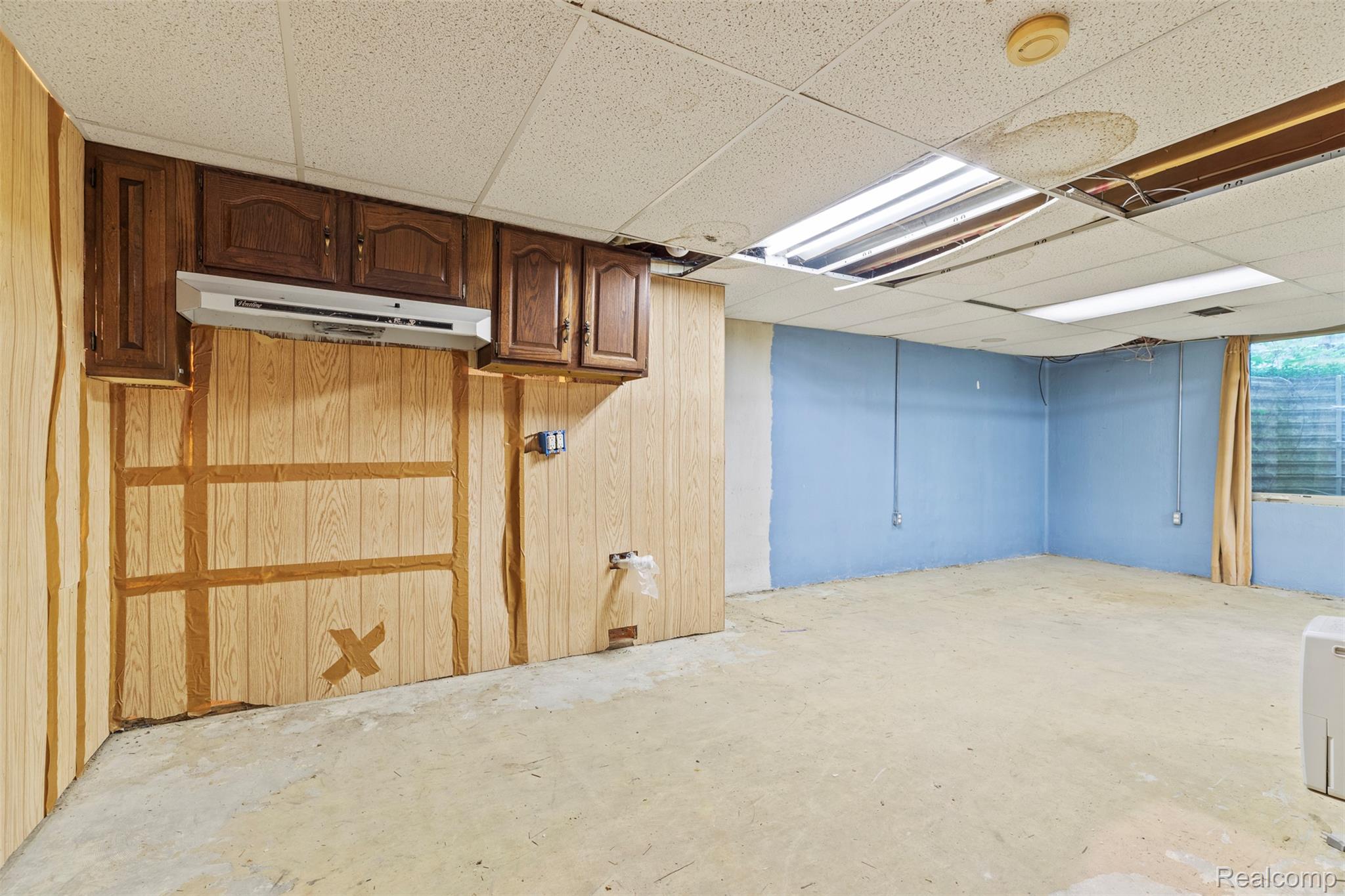 309 Windy Bluff Street Flushing, MI 48433 - Photo 22 of 32 Unfinished space featuring a drop ceiling, concrete flooring, and partial wood-finish paneling