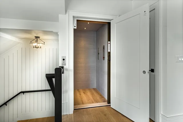 a view of a hallway with wooden floor and staircase