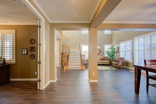 a kitchen with granite countertop a stove a sink a dining table and chairs