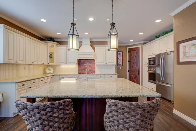 a view of a kitchen with stainless steel appliances granite countertop a sink and cabinets