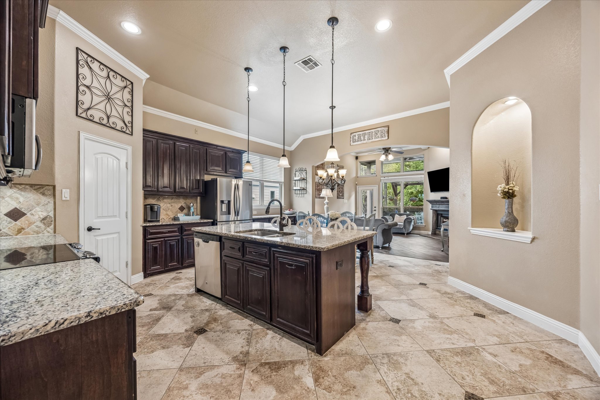 108 Rhinestone Cove Liberty Hill, TX 78642 - Photo 13 of 32 Spacious kitchen featuring dark wood cabinetry, granite countertops, stainless steel appliances, and a central island with pendant lighting