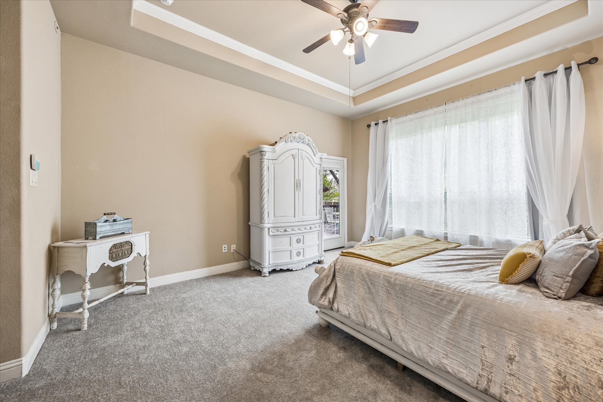 108 Rhinestone Cove Liberty Hill, TX 78642 - Photo 17 of 32 Tray ceiling with crown molding, ceiling fan, carpeted flooring, and glass-paned double doors