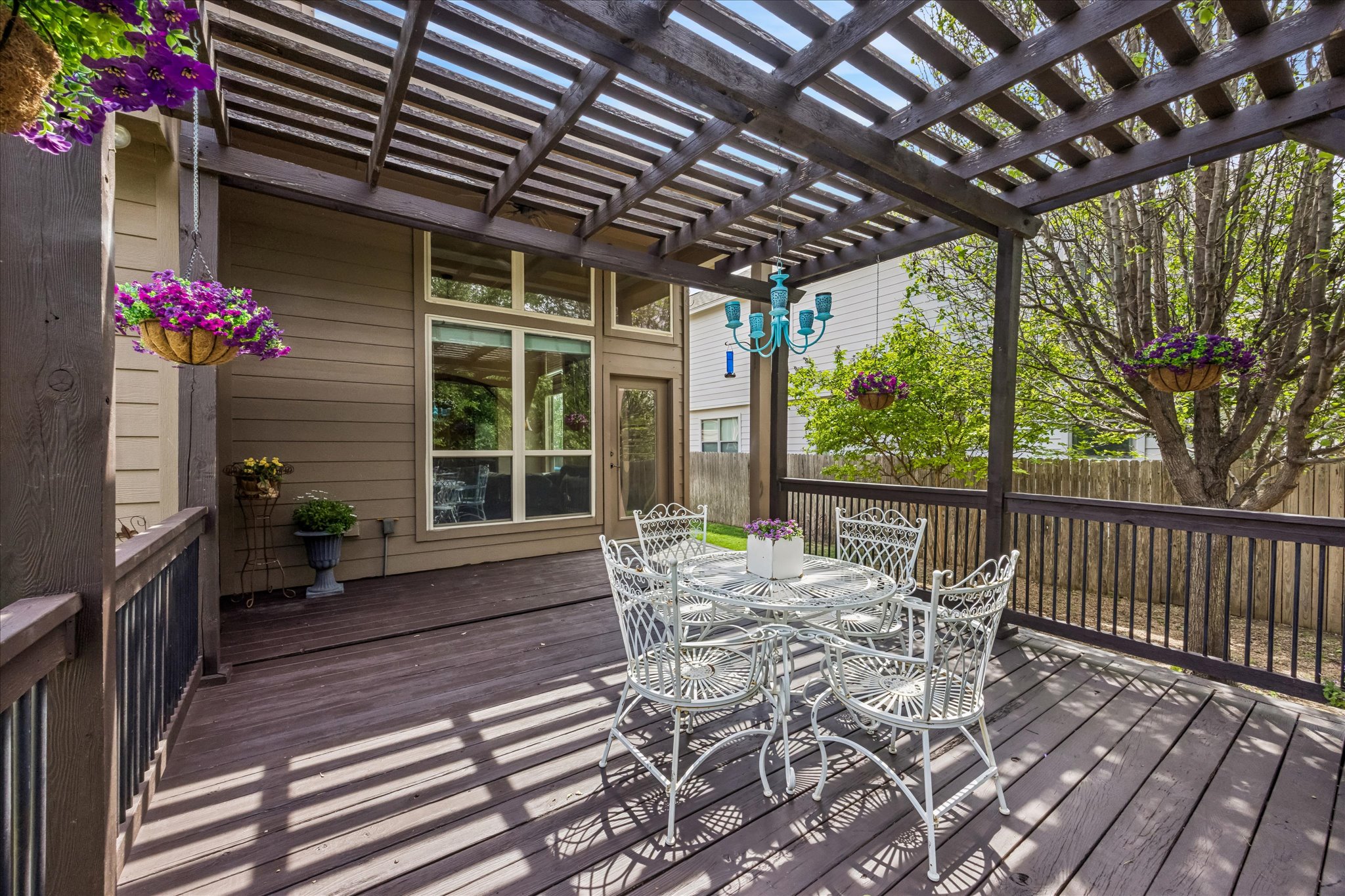 108 Rhinestone Cove Liberty Hill, TX 78642 - Photo 28 of 32 Spacious outdoor deck featuring a wooden pergola, privacy railing, and a turquoise chandelier