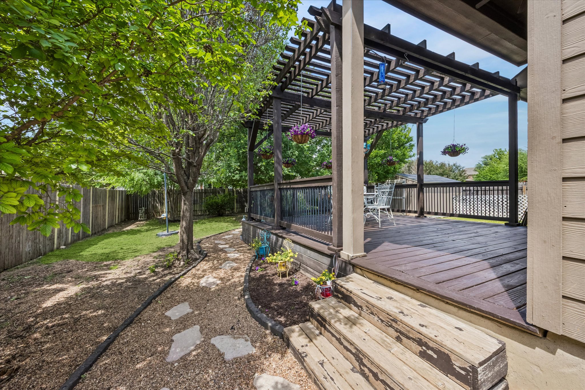 108 Rhinestone Cove Liberty Hill, TX 78642 - Photo 29 of 32 Spacious backyard deck featuring a dark wood pergola, wood plank decking, and a decorative railing