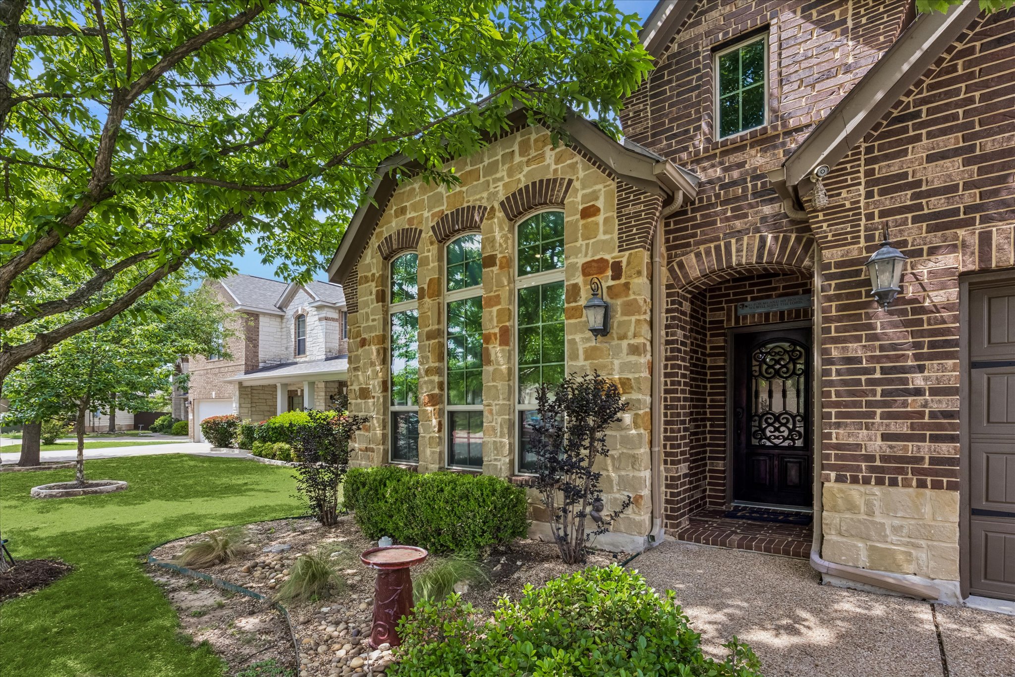 108 Rhinestone Cove Liberty Hill, TX 78642 - Photo 3 of 32 Stone and brick facade with arched entryway and decorative ironwork front door