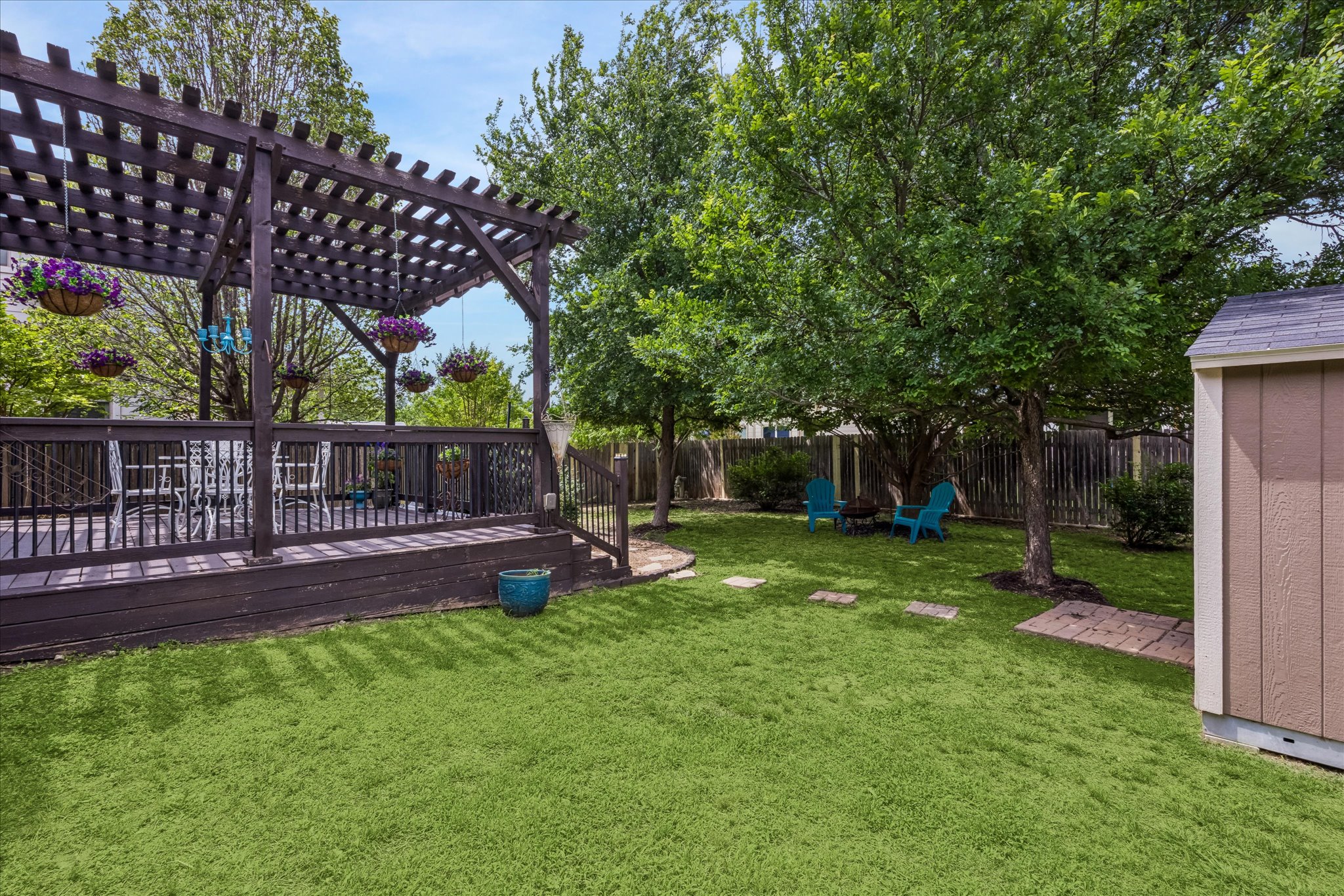 108 Rhinestone Cove Liberty Hill, TX 78642 - Photo 31 of 32 Expansive backyard featuring a wood-finish deck with a pergola, a storage shed, established trees, and stepping stone pathways