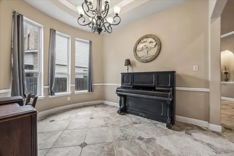 a dining room with furniture a chandelier and window