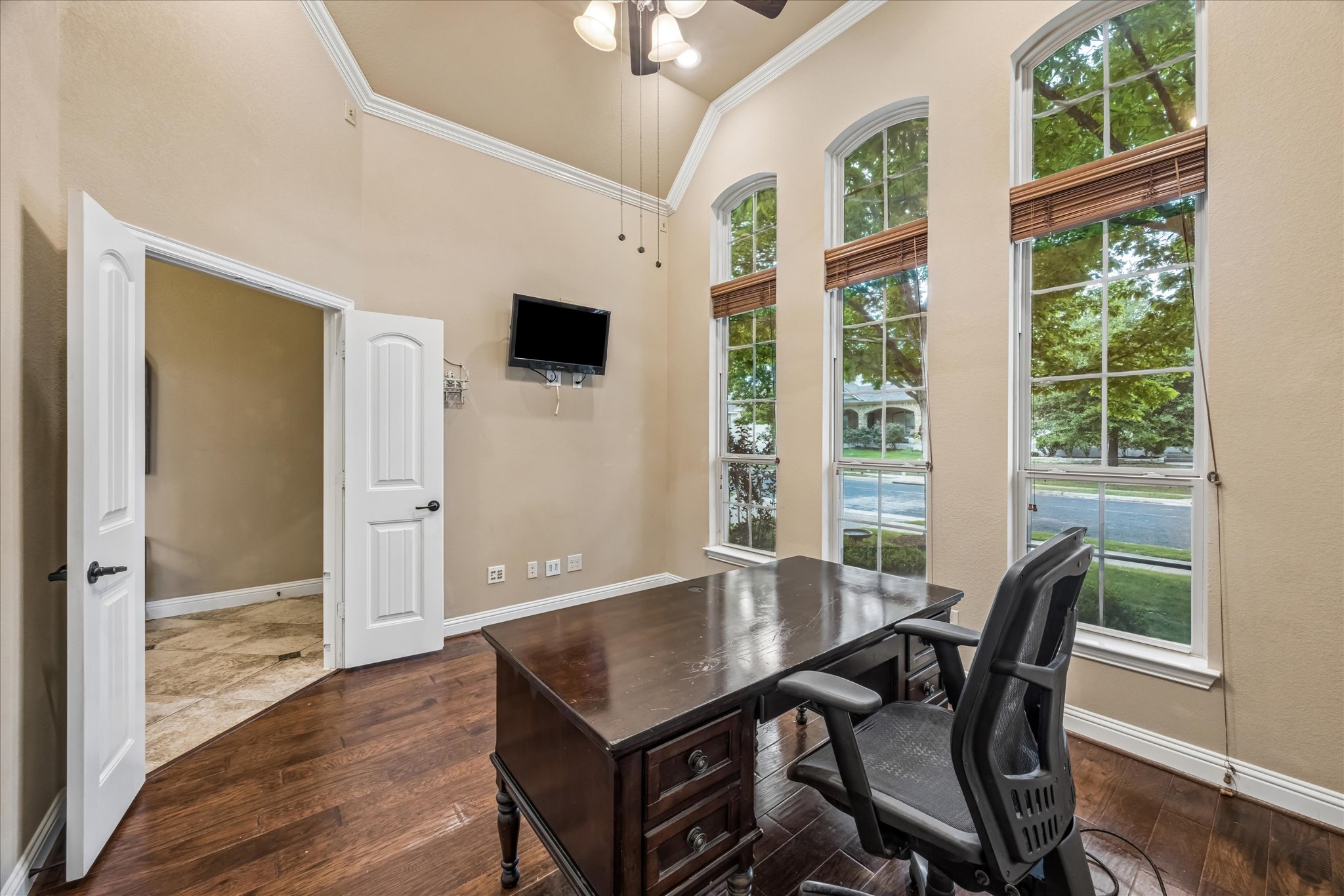 108 Rhinestone Cove Liberty Hill, TX 78642 - Photo 8 of 32 Vaulted ceiling room featuring three arched windows with wood blinds, wood-finish flooring, and crown molding