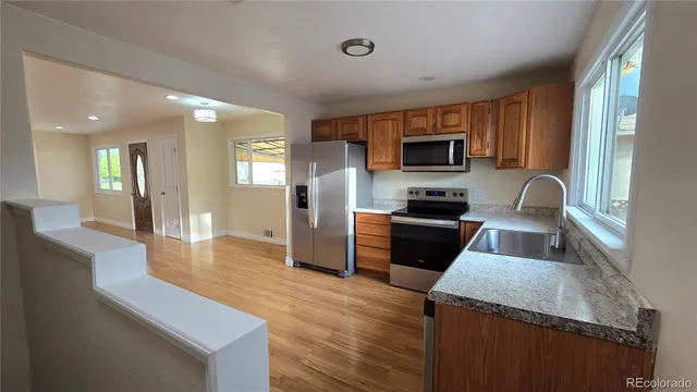 a kitchen with granite countertop stainless steel appliances and wooden cabinets
