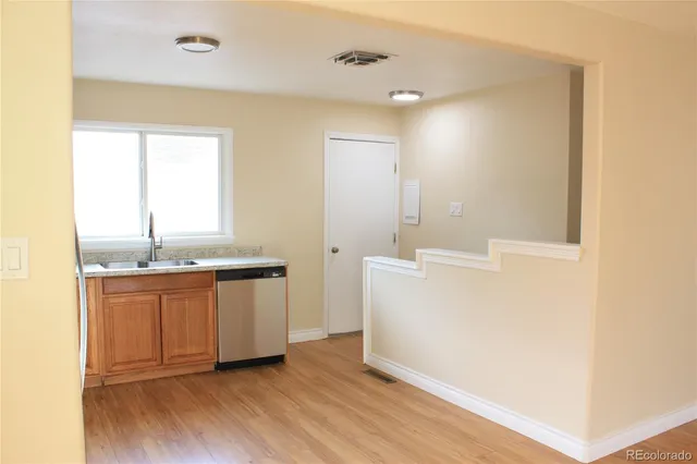 a room with a sink cabinets and wooden floor