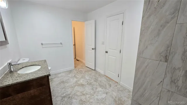 a bathroom with a granite countertop sink and a mirror