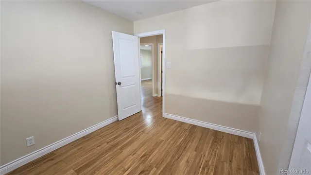 a view of an empty room with wooden floor