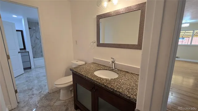 a bathroom with a granite countertop sink and a mirror