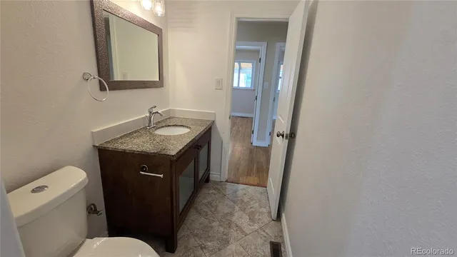 a bathroom with a granite countertop sink and a mirror