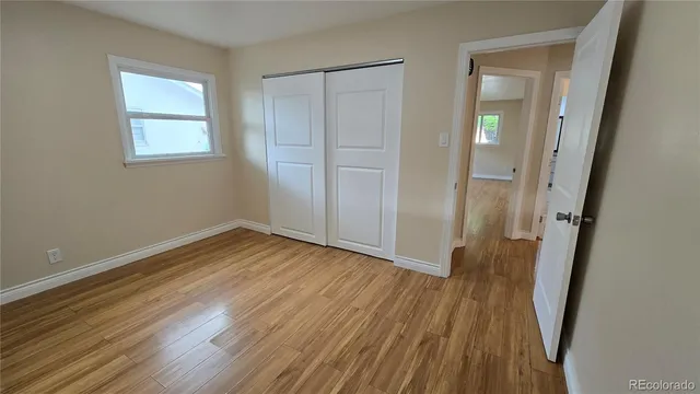 an empty room with wooden floor and a window
