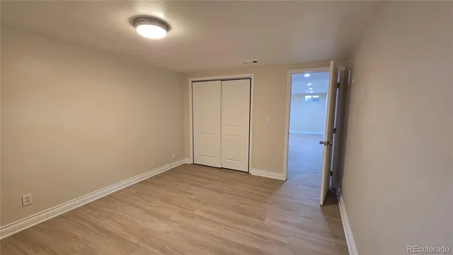 an empty room with wooden floor and closet