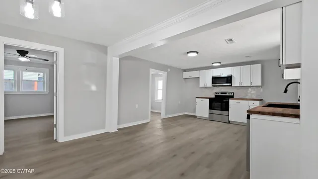 a kitchen with granite countertop a stove top oven and cabinets