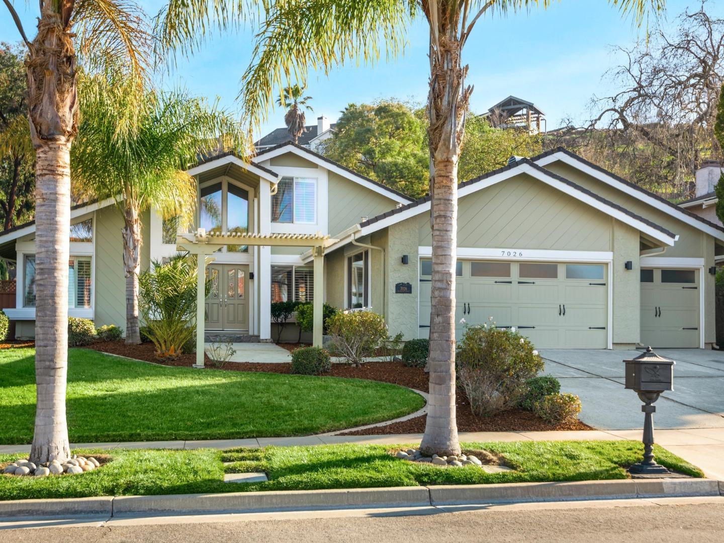 a front view of a house with a yard and palm trees