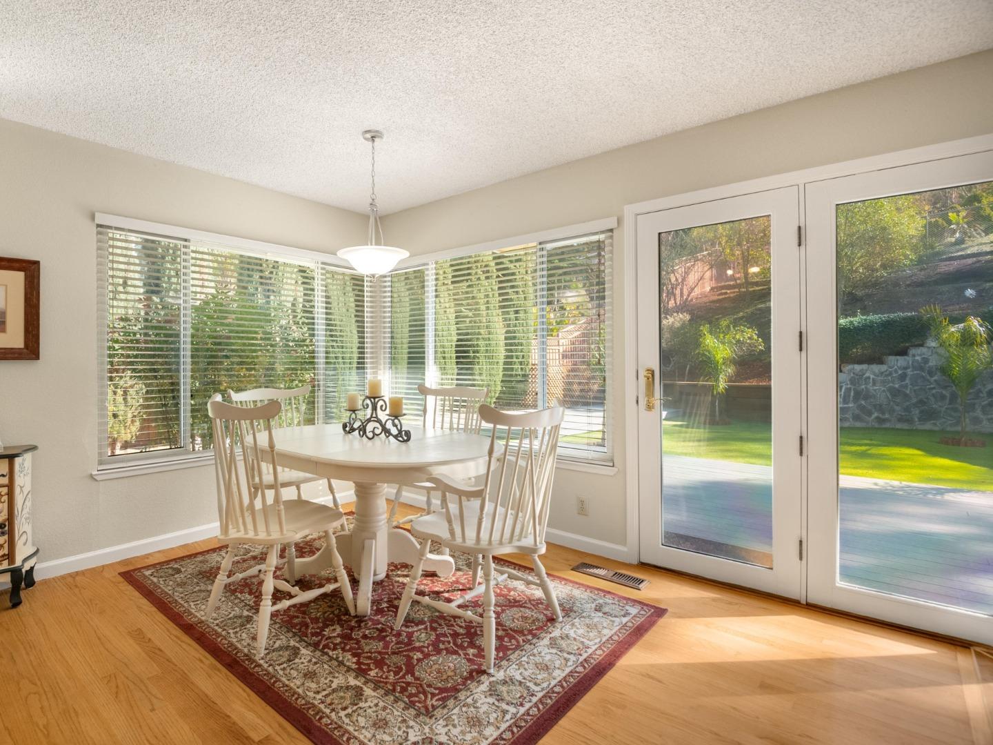 7026 Burnside Drive San Jose, CA 95120 - Photo 15 of 60 a dining room with wooden floor and a floor to ceiling window