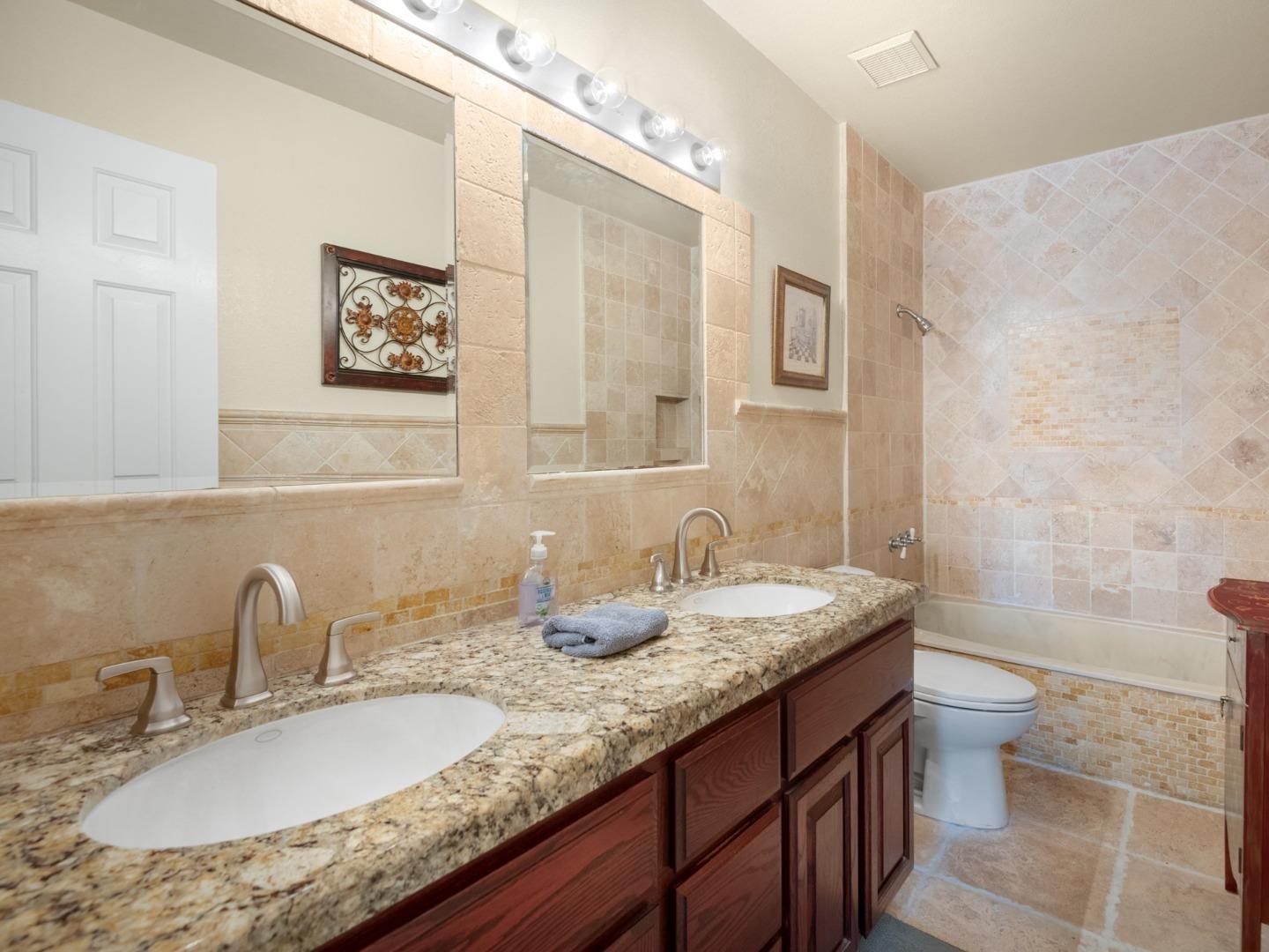 7026 Burnside Drive San Jose, CA 95120 - Photo 28 of 60 a bathroom with a granite countertop sink a toilet and a mirror