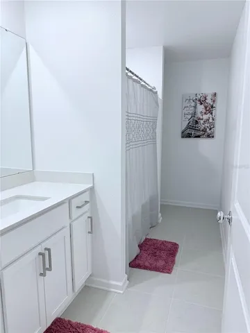 a bathroom with a sink a toilet and shower curtain