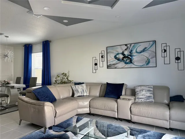 a living room with furniture ceiling fan and a large window