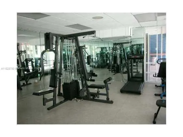 a room with lots of white furniture and a chandelier