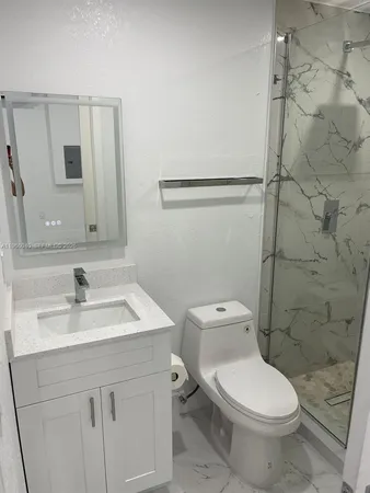 a bathroom with a toilet sink vanity and mirror